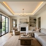 Modern living room featuring a tray ceiling with warm cove lighting.